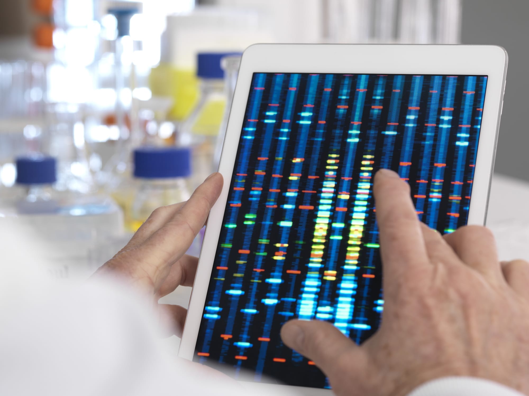 Scientist viewing results of a genetic test on a digital tablet.