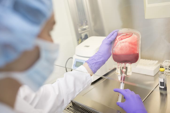Photo shows a scientist holding a bag of umbilical cord blood in a lab/Getty Images