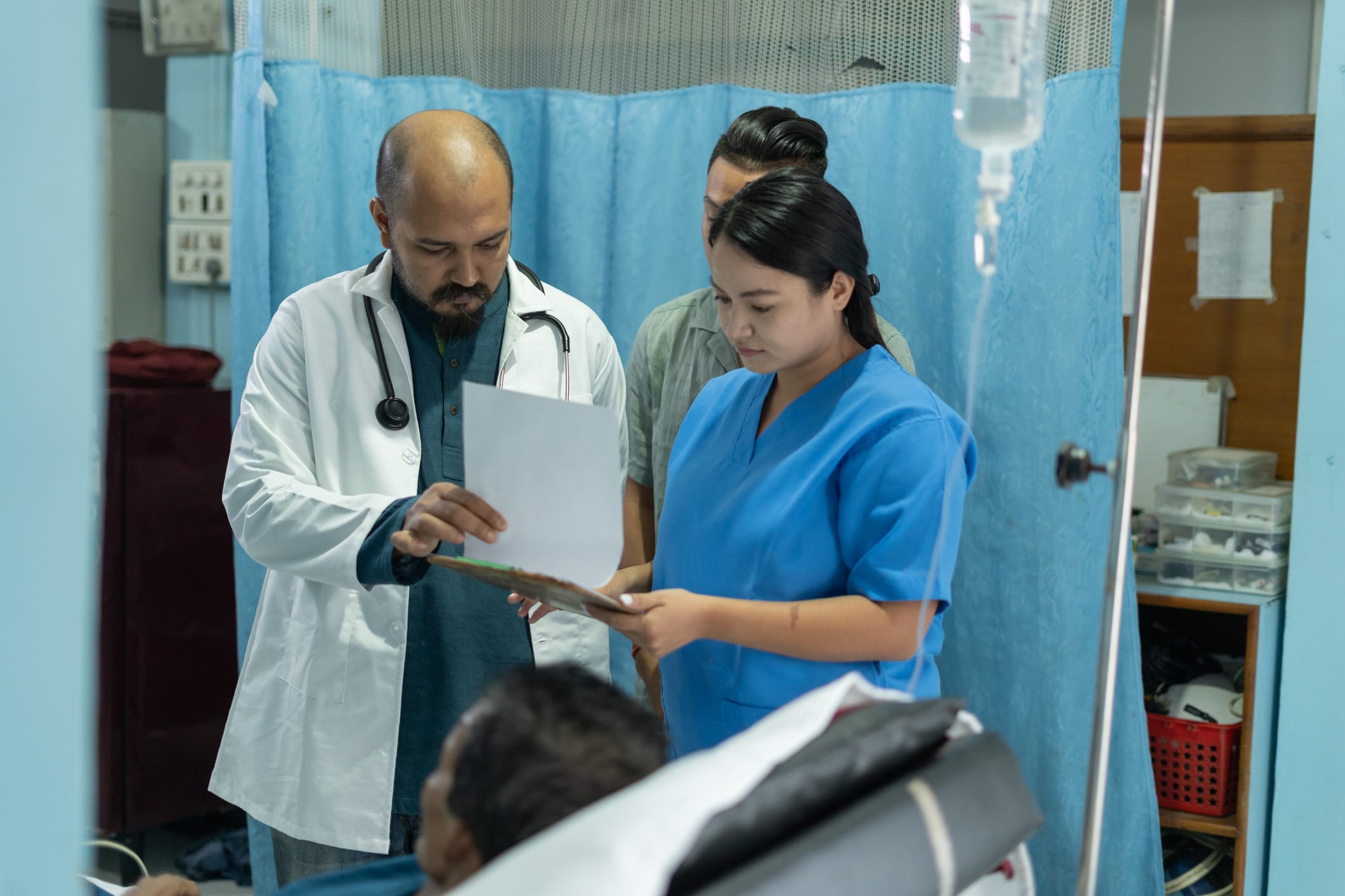 Doctor speaking with nurse in a clinic while reviewing chart