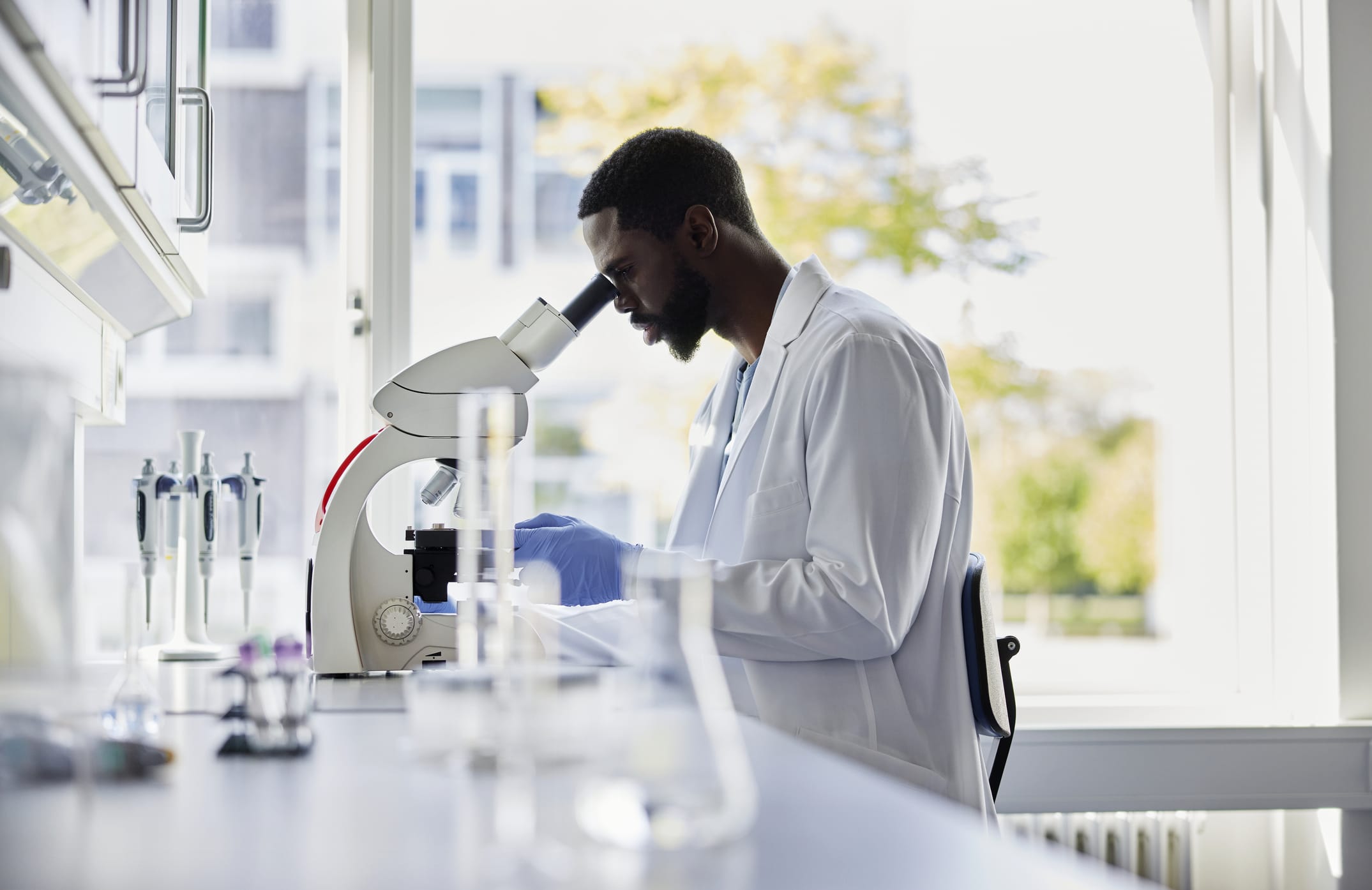 Researcher looking through a microscope in a lab