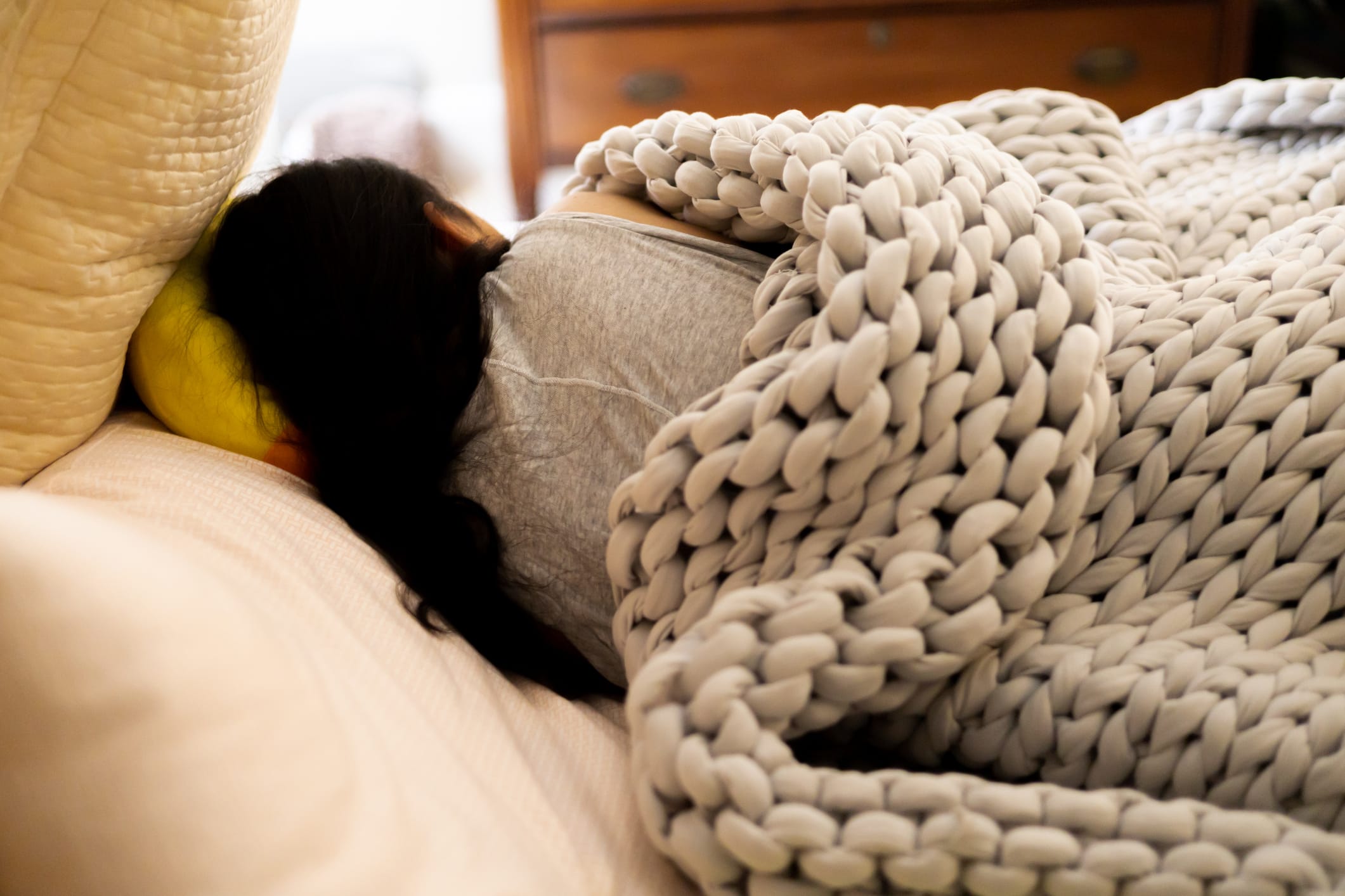 Woman sleeping under a knit throw