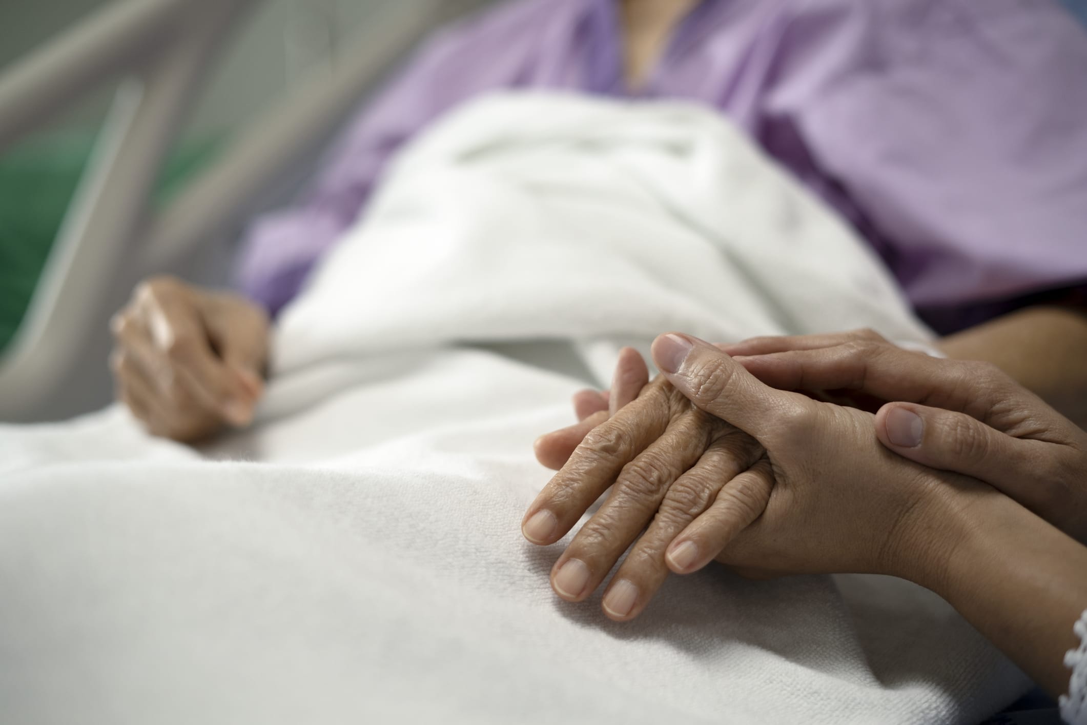 Holding an elderly woman's hand in the hospital